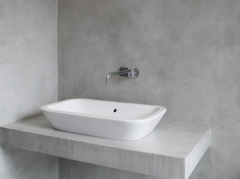 Grey Microcement wall and shelf behind bathroom countertop basin