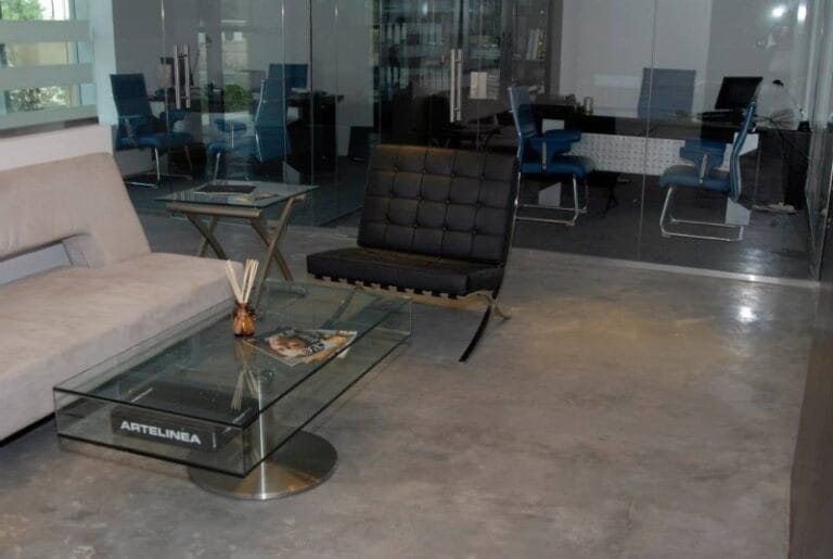 Dark Microcement floor in commercial office reception with glass partitions