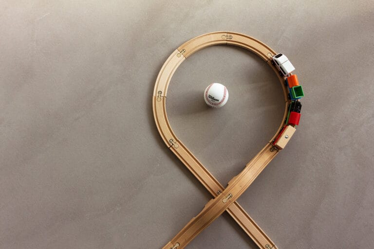 ErreLAB Pietra Continua Basalto floor finish, styled with a toy train track and baseball
