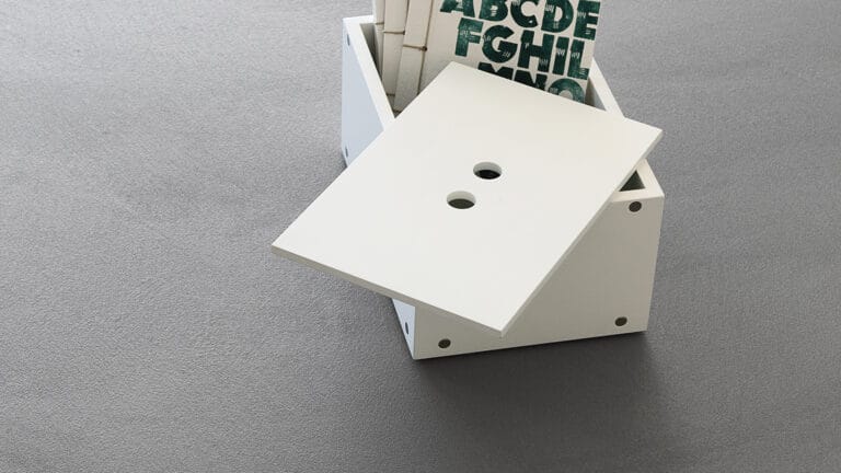 ErreLAB Pietra Continua Basalto dark textured floor with decorative alphabet box