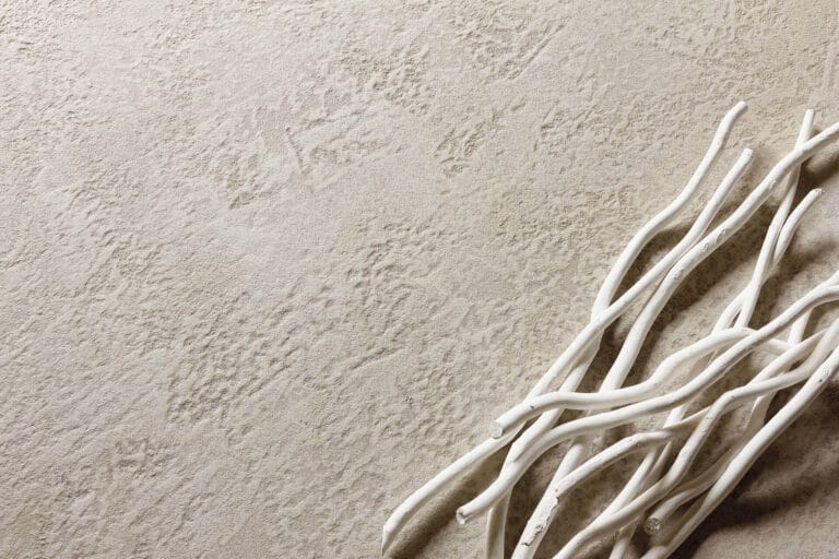 ErreLAB Pietra Continua Calcare textured finish close-up with white branches