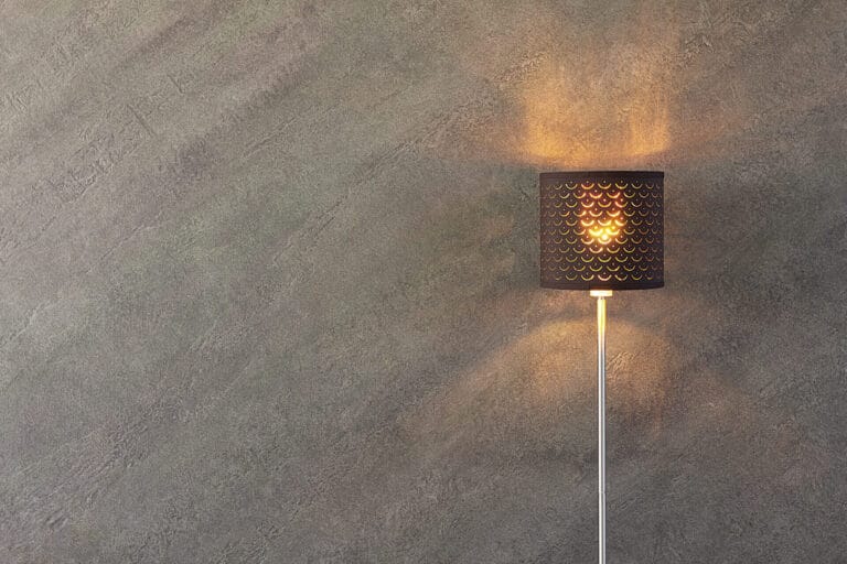 Wall lamp with warm glow illuminating ErreLAB Pietra Continua Scisto textured surface