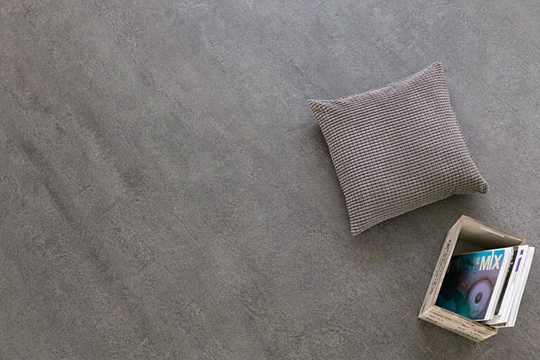 Grey cushion and magazines on ErreLAB Pietra Continua Scisto dark textured surface
