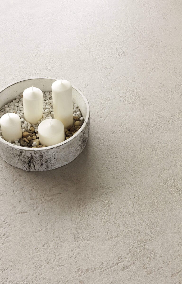 White decorative bowl with elements arranged on ErreLAB Pietra Continua Travertino textured surface