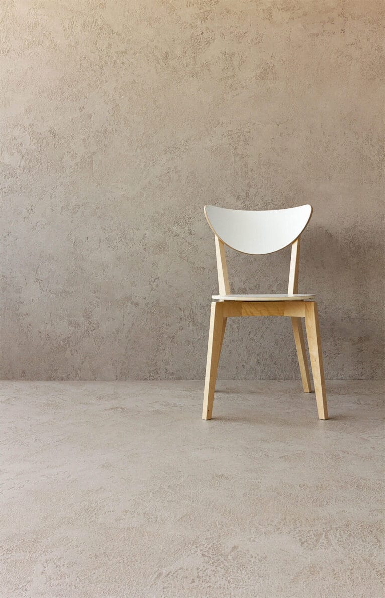 Modern interior with white and wooden chair against ErreLAB Pietra Continua Travertino textured wall finish