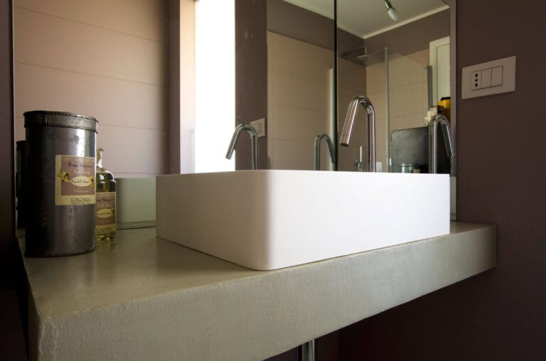 ErreLAB Spatolato applied to bathroom vanity countertop with light, smooth finish and mirror