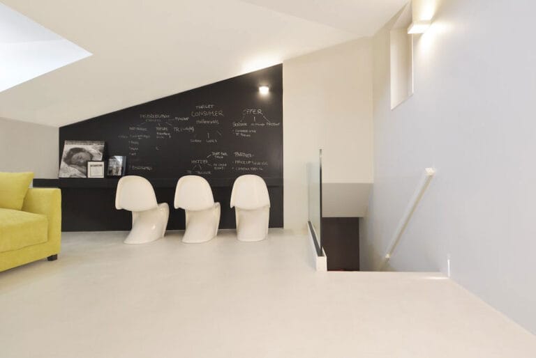 ErreLAB Spatolato light cream flooring in a kitchen-dining area with modern seating and dark accent elements
