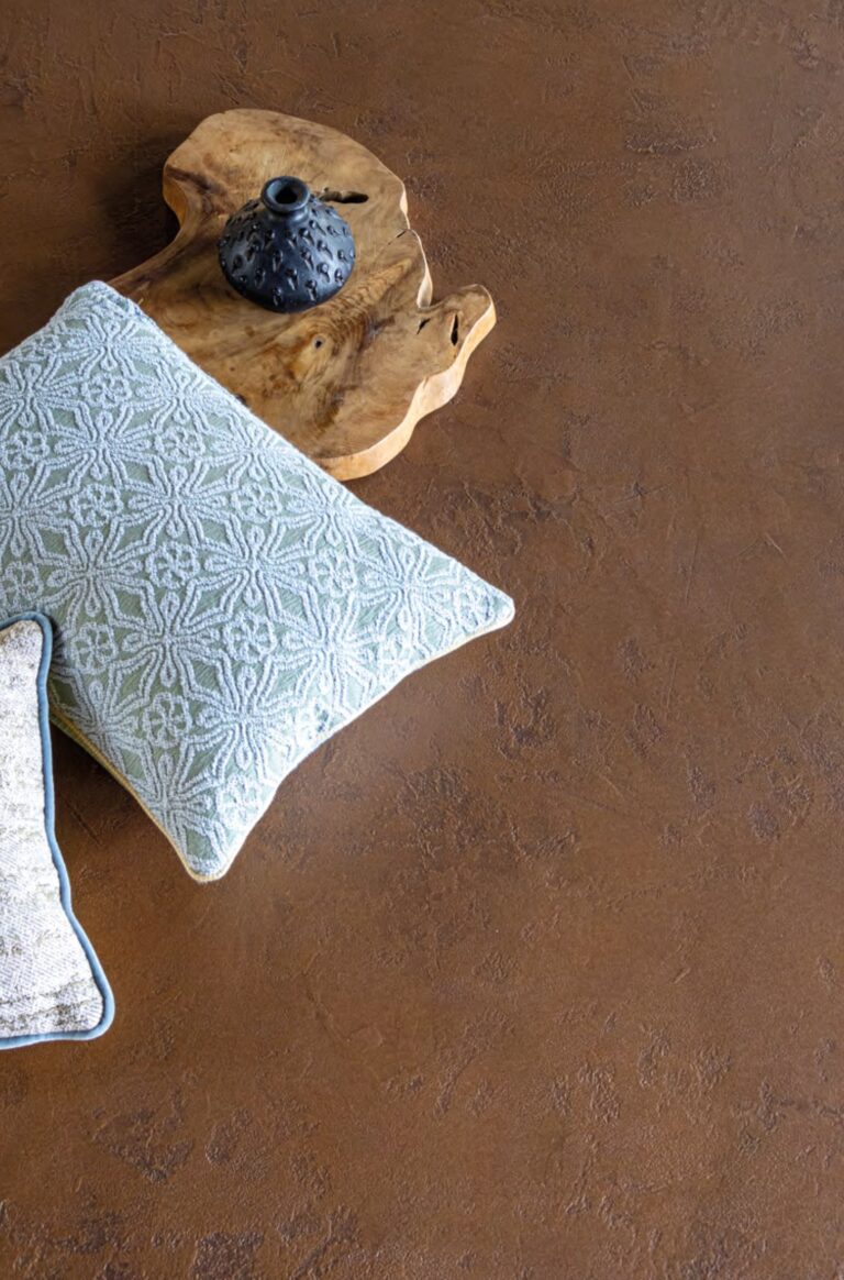 ErreLAB Metallo Continuo floor in bronze with a cushion and wooden tray