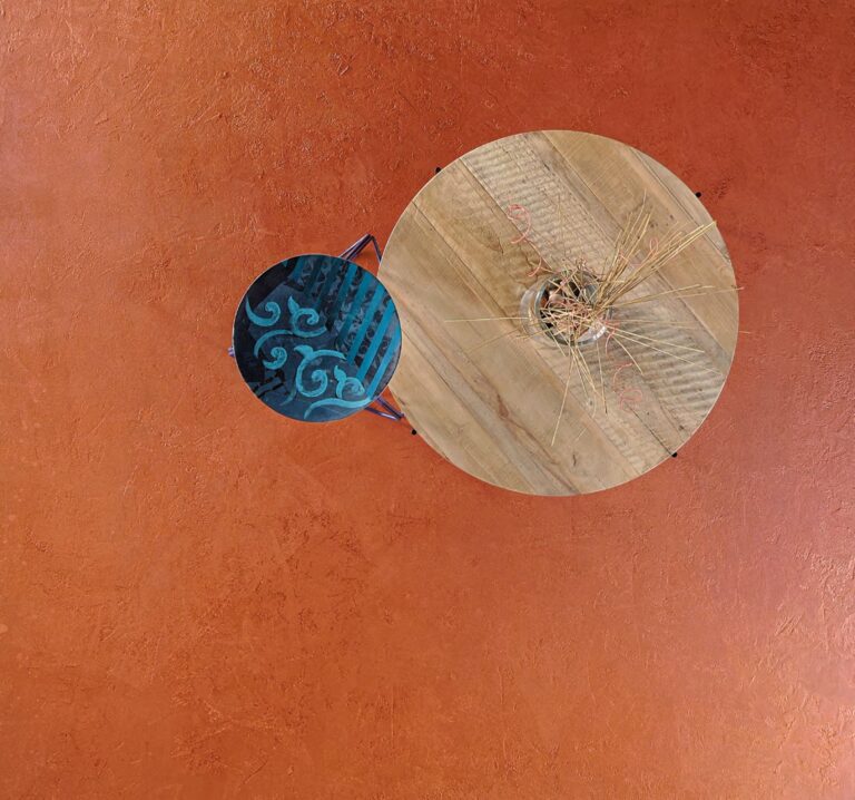 ErreLAB Metallo Continuo floor in copper with a round wooden table