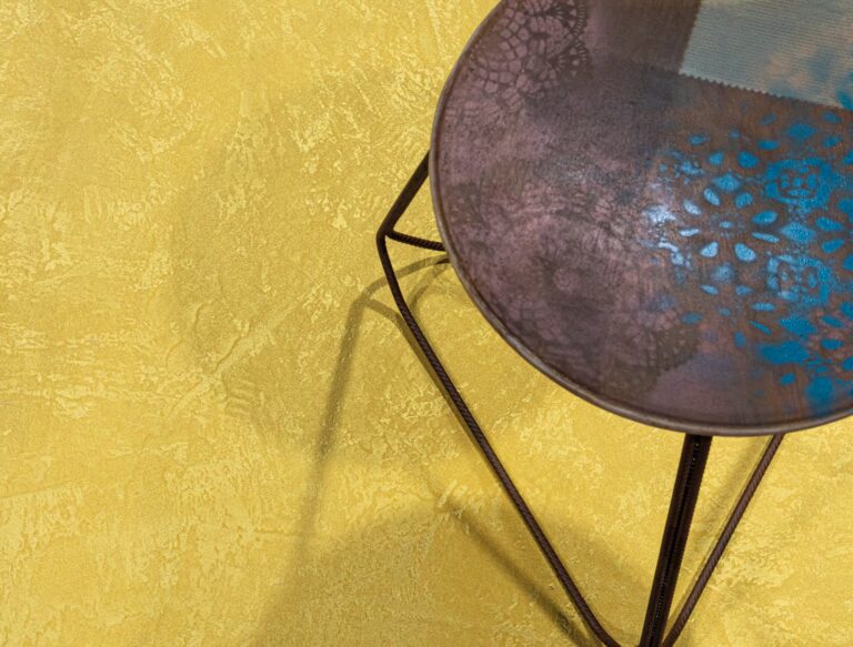 ErreLAB Metallo Continuo floor in gold with a metal side table