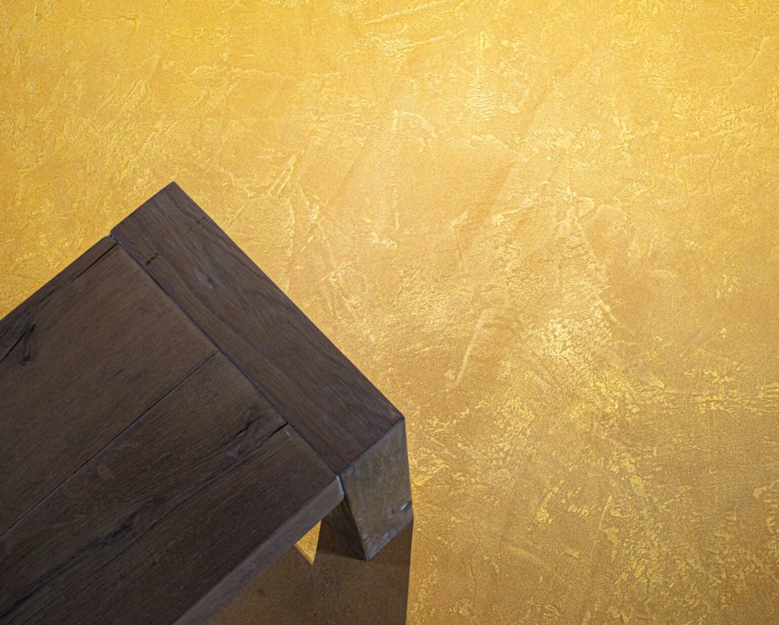 ErreLAB Metallo Continuo floor in gold with a dark wooden table