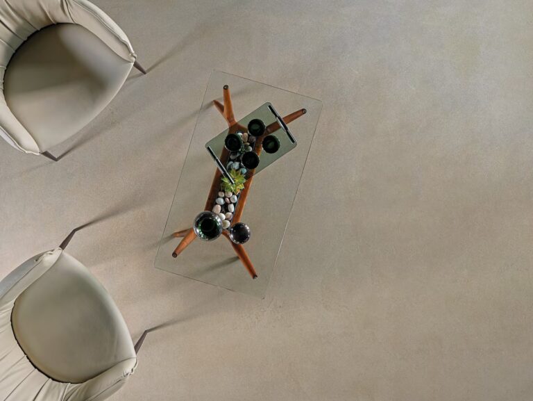 ErreLAB Metallo Continuo floor in pale gold with white chairs and a glass table